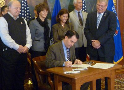 Alliance President and CEO Cheryl DeMars watches as Governor Walker signs Senate Bill 203 into law