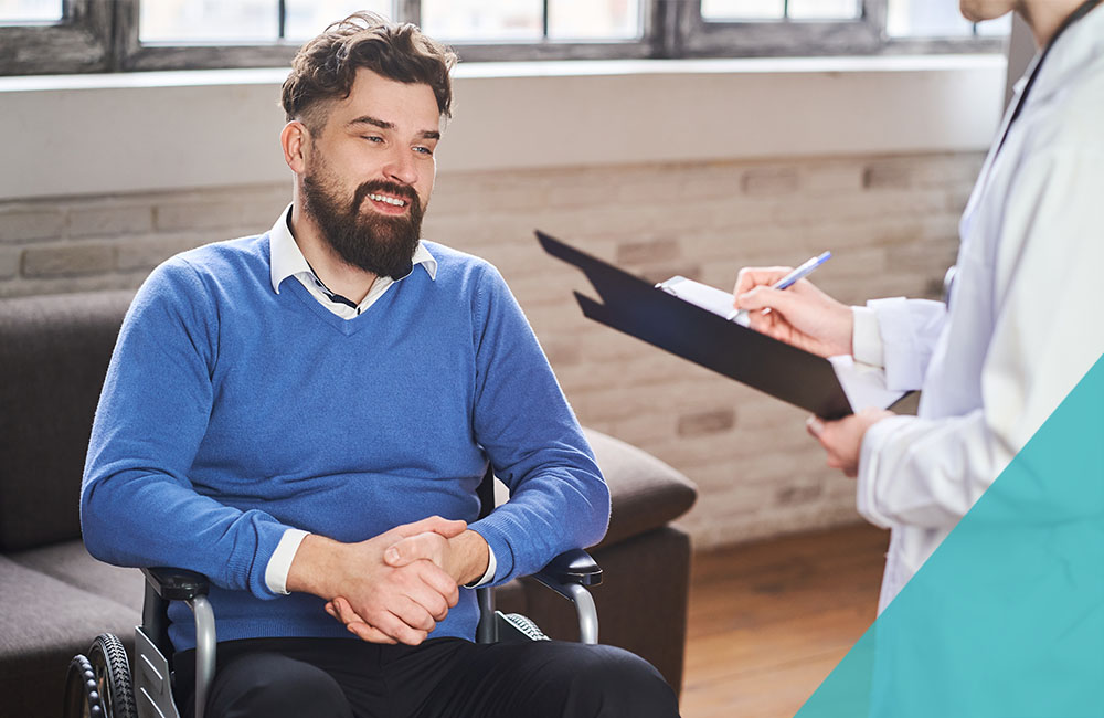 Happy patient in wheelchair talking to physician