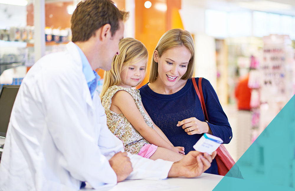 A pharmacist giving medication to a mother and daughter